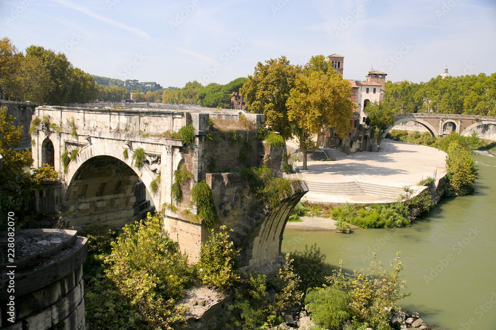The remains of the ancient Ponte Rotto, with Isola Tiberina (Tevere Island) in the background, Roma, Italy