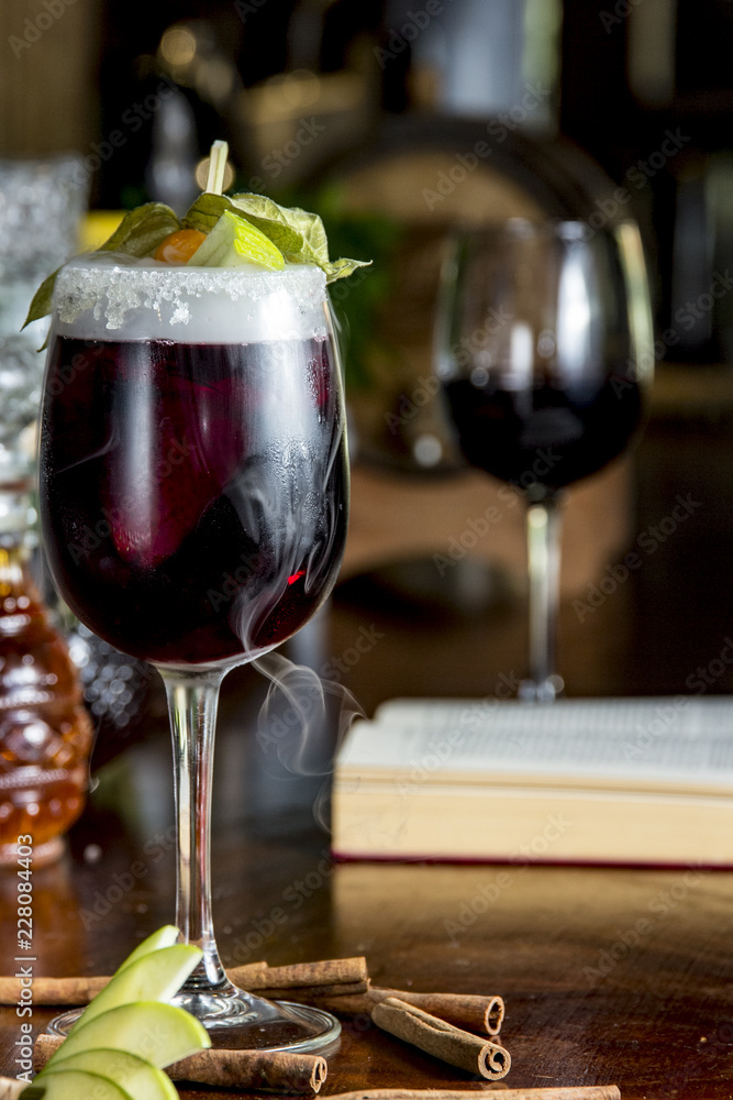 Glass of red wine cocktail with fruits and dry ice, on wooden table Glass of red wine cocktail with fruits and dry ice, on wooden table