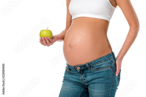 cropped view of pregnant woman holding green fresh apple isolated on white