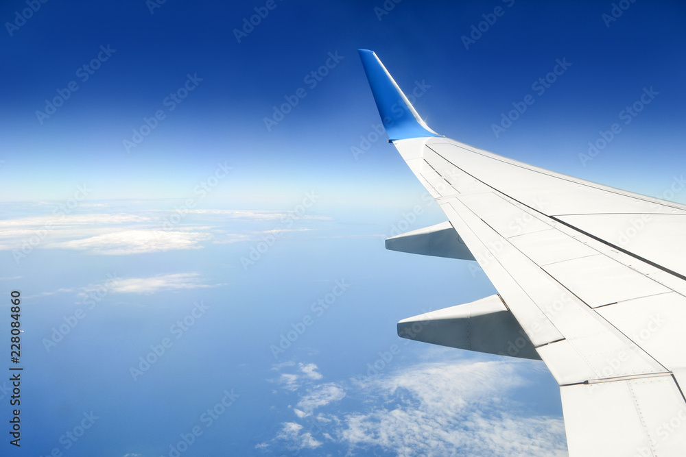 Tranquil view of blue sky with some clouds and sea under the wing of plane. Concept of peaceful. Travel and freedom concept. Tranquil view of blue sky with some clouds and sea under the wing of plane. Concept of peaceful. Travel and freedom concept.