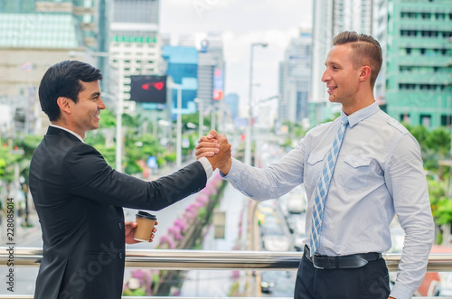  Business hand shake between two colleagues - greeting, dealing, merger and acquisition concepts.