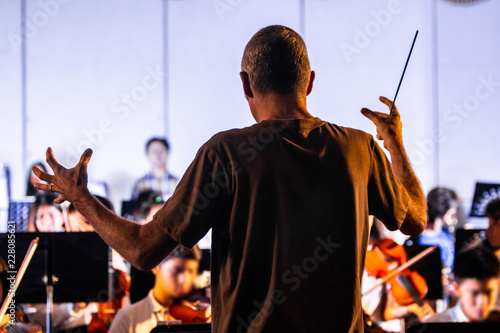 Foto Back view of a male conductor directiing his band at a local school