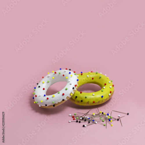 Humorous imitation of donuts from colored bagels with multi-colored pins