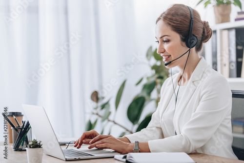 executive female operator working with headset and laptop in call center photo