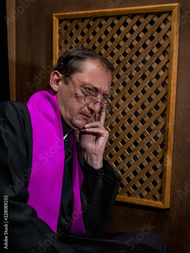 Portrait of a priest in his confessional photo