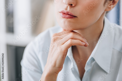 cropped shot of businesswoman touching chin with hand at office