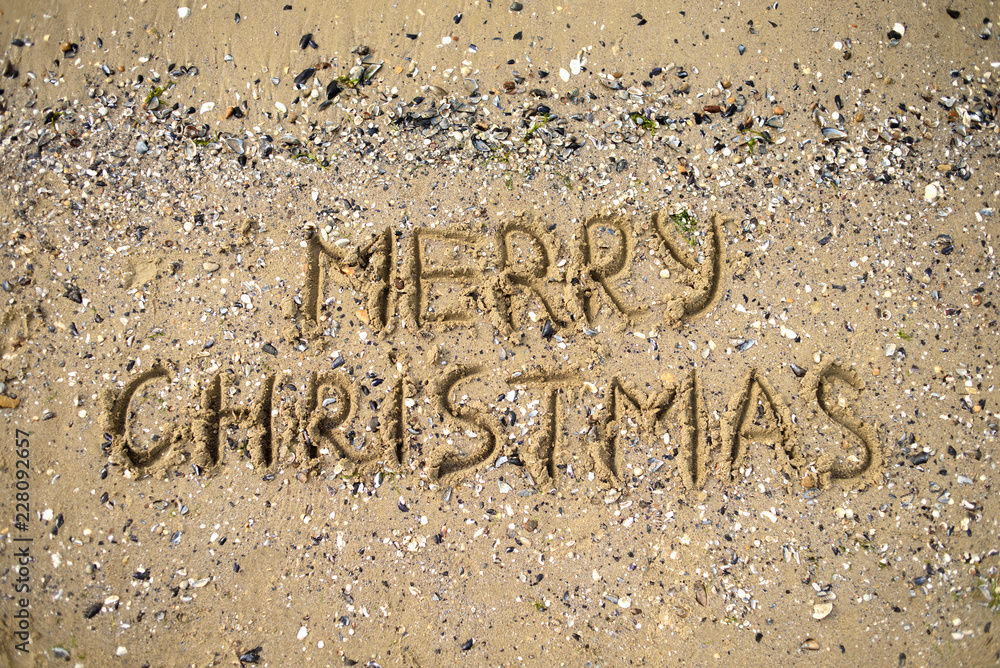 Fototapeta premium Merry Christmas written on tropical beach sand, copy space. Holiday concept