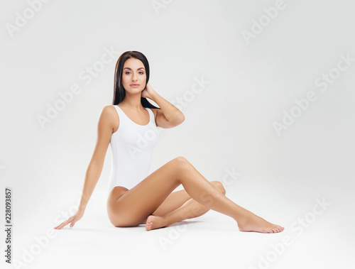 Fit and sporty girl in white swimsuit. Sport, fitness, diet, weight loss and healthcare concept. © Acronym