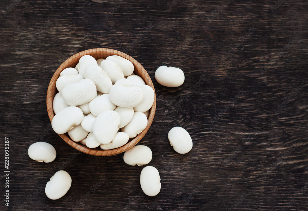 white beans on a dark wooden background in a cup white beans on a dark wooden background in a cup