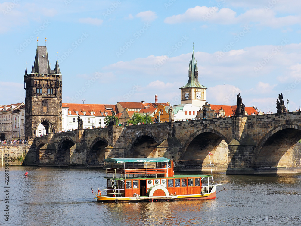 Fototapeta premium Old ship passes through Charles Bridge in Prague, Czech Republic. Vlatva River
