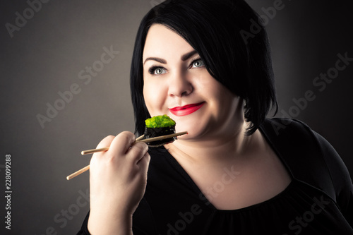happy face fat woman with sushi rolls in hand