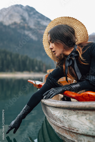 Woman in hat in wooden boat