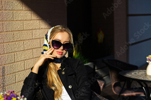 Outdoor shot of a wonderful model with natural makeup wearing shawl and black autumn coat. Space for text