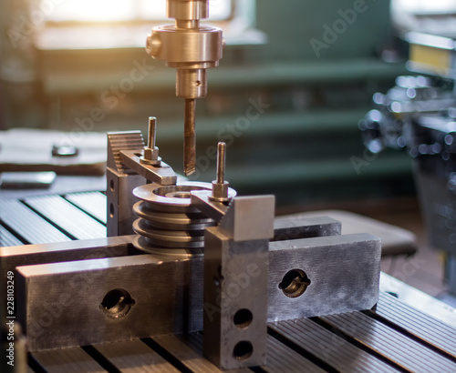 The man specialist checks the measuring tool with the size of drilling a metal pulley and inserts a drill into a drilling machine, individual entrepreneur