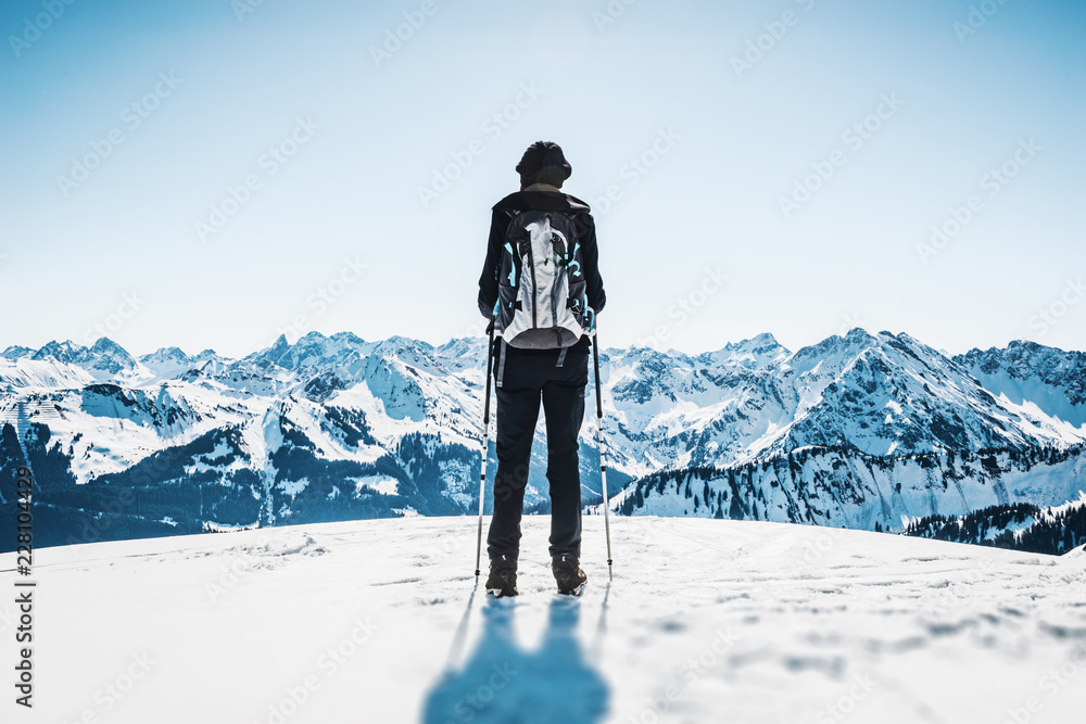Backpacker standing against winter mountains