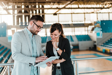 Two sports manager talking at sports hall.