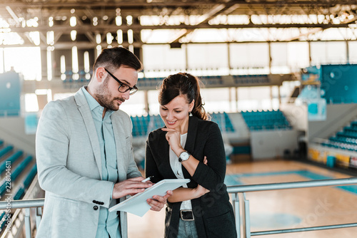 Two sports manager talking at sports hall. photo