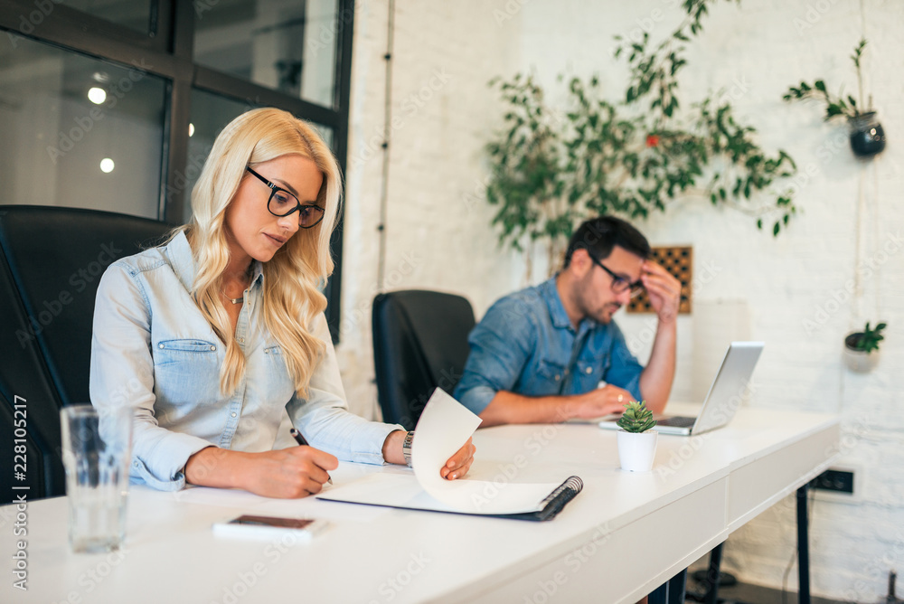 Two business people working separately side by side. Two business people working separately side by side.