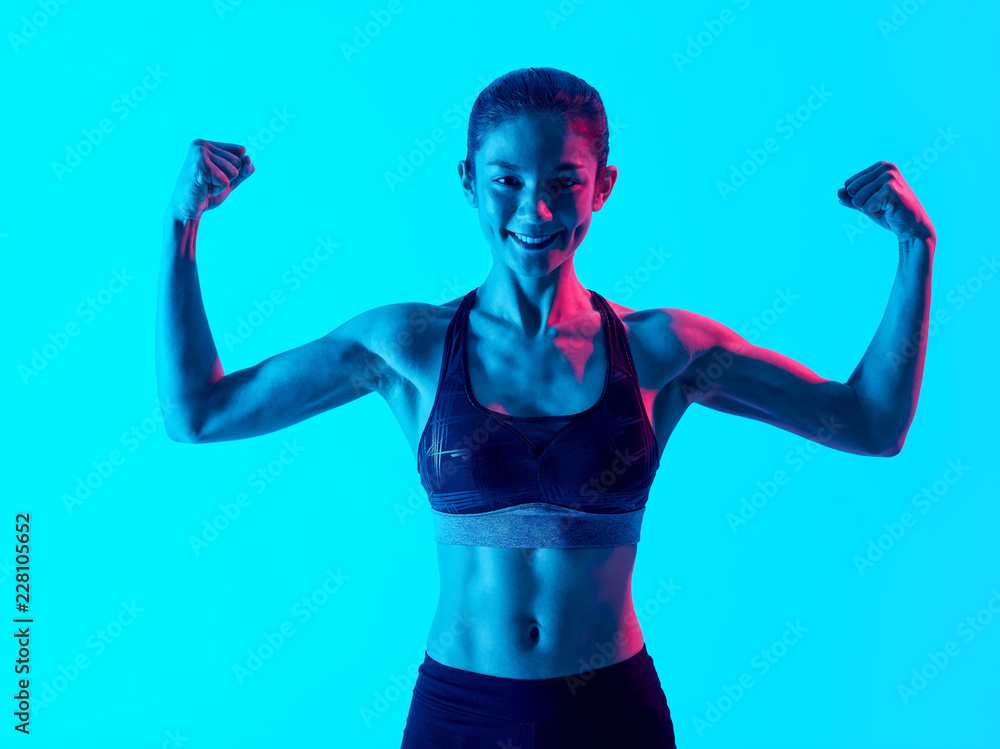 one mixed races muscular woman exercsing fitness exercices isolated on blue blackground