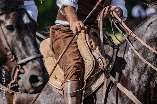 Fotografía Scenes from a rodeo and equestrian show, warming up phase, details of saddles, clothing, stirrups and brown horses