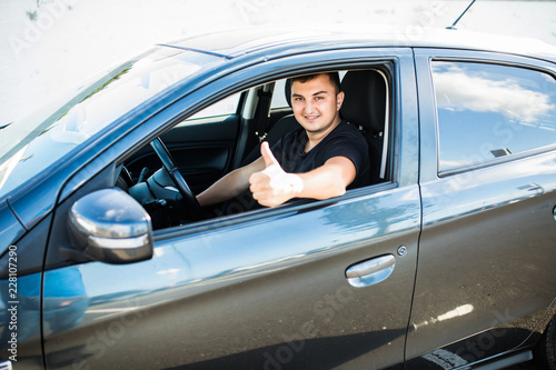 Handsome young Man in a car with thumbs up