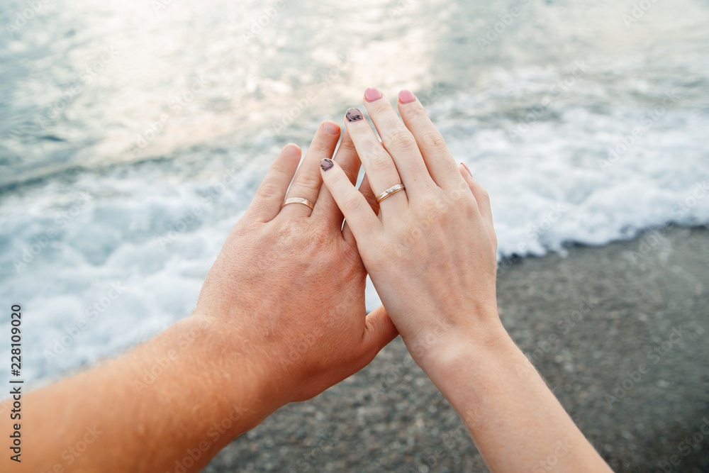 hands newlyweds on the background of the sea, honeymoon hands newlyweds on the background of the sea, honeymoon