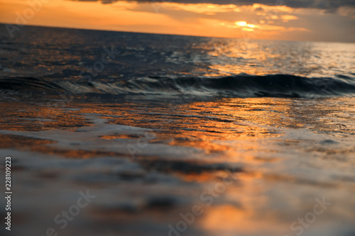 sunset at sea  bottom view  sand at sunset  waves with foam