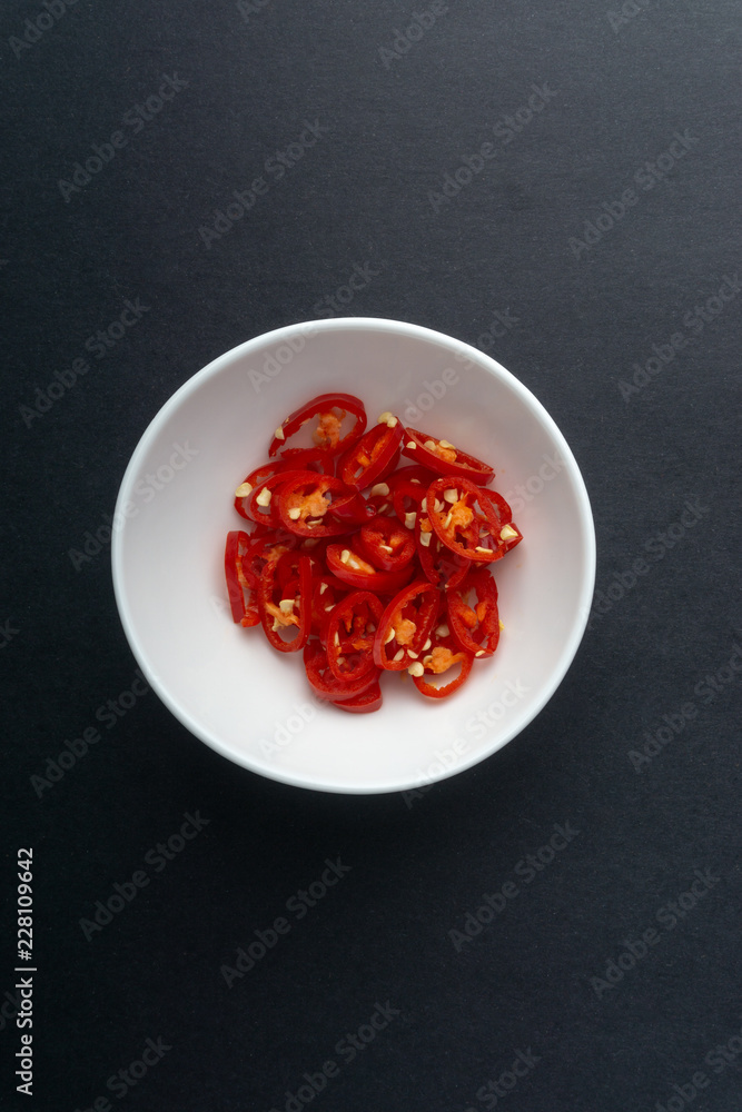 Red chili slices on dark background with selective focus and crop fragment Red chili slices on dark background with selective focus and crop fragment