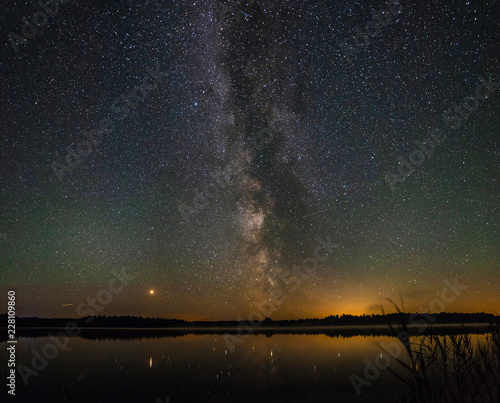 Panorama of the beautiful milky way over a large lake on a summer night