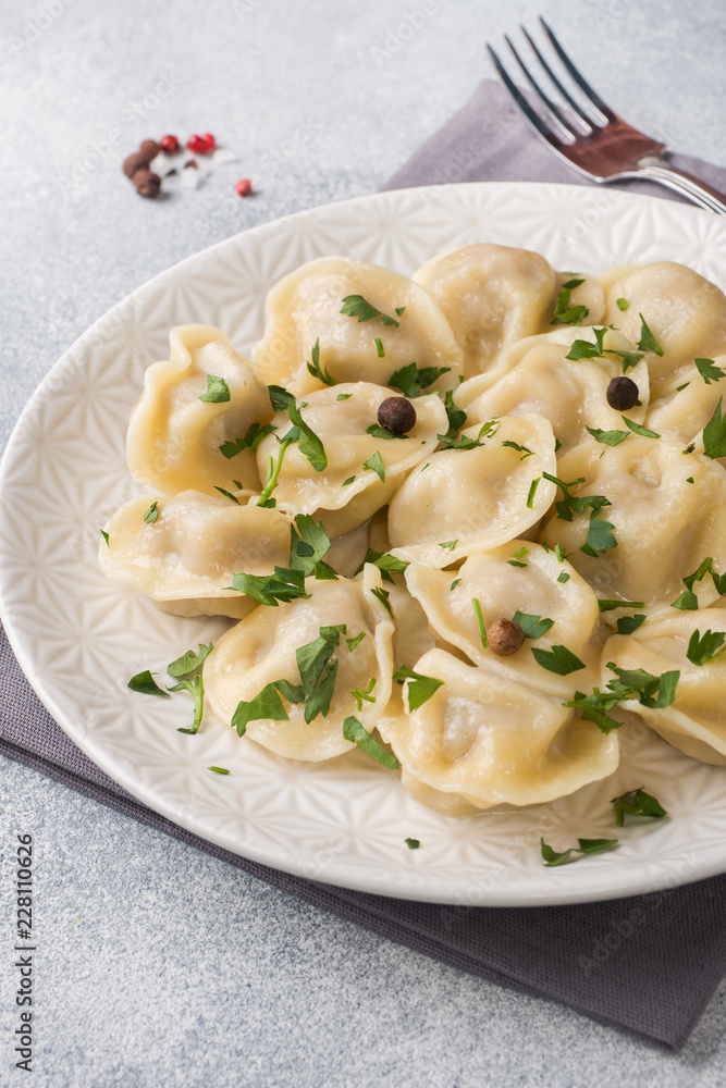 Traditional pelmeni, ravioli, dumplings filled with meat on plate, russian kitchen Traditional pelmeni, ravioli, dumplings filled with meat on plate, russian kitchen