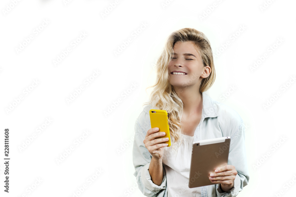 Young very beautiful business girl with a phone and ipad in her hands smiles and laughs at what she saw in on a white background Young very beautiful business girl with a phone and ipad in her hands smiles and laughs at what she saw in on a white background