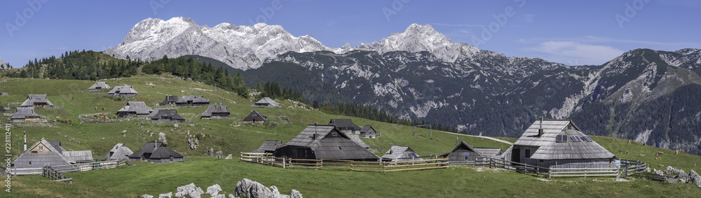 Panoramic view of traditional cottages on Velika planina (Big Pasture Plateau) in front of Kamnik-Savinja Alps, Slovenia