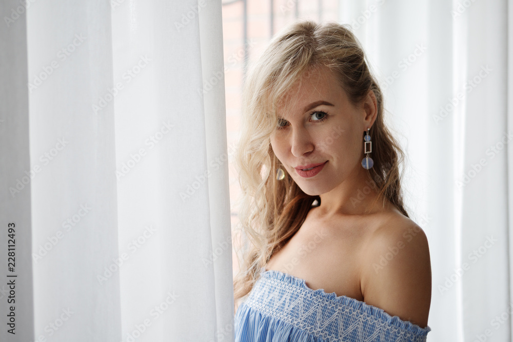 Beautiful blonde on the background of the window. Slender girl with white hair Beautiful blonde on the background of the window. Slender girl with white hair