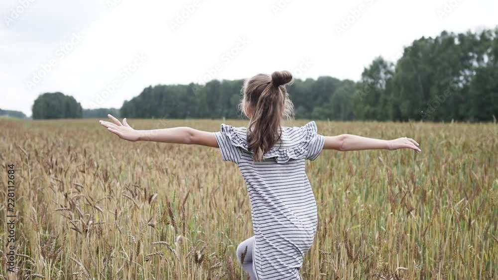 Little girl in the wheat field. Slow motion.