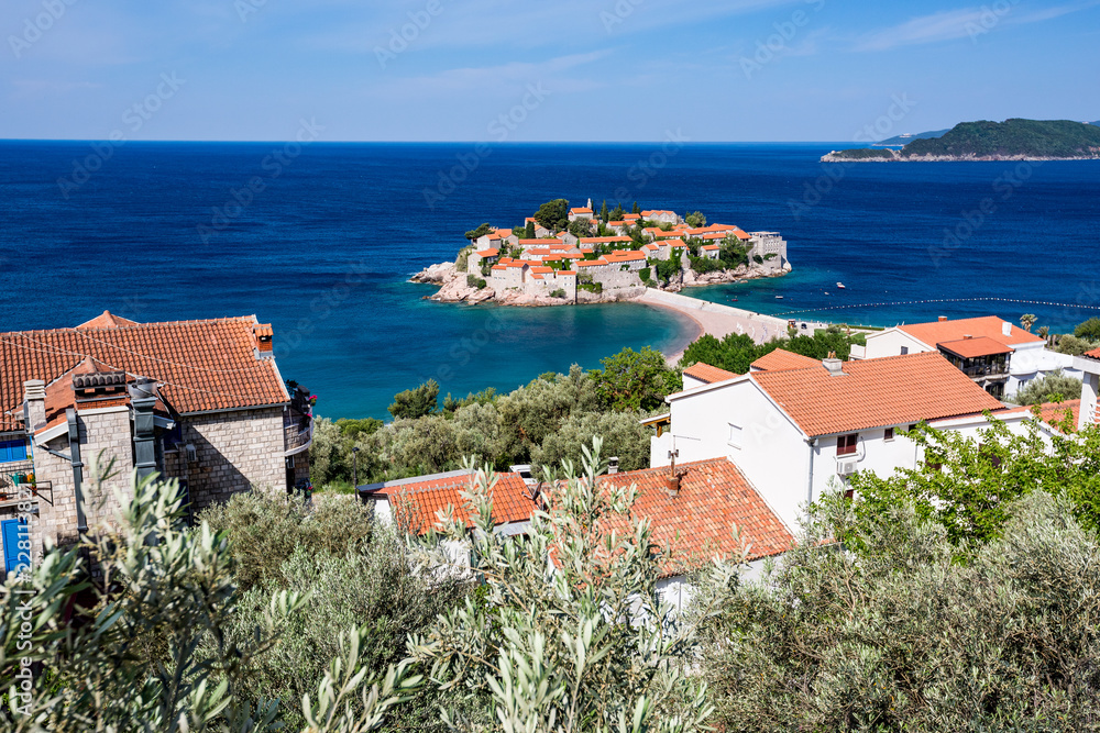 Springtime blue water landscape view of St. Stephan island in Adriatic Sea in Montenegro, famous tourist and holiday destination in Europe with stunning architecture and crystal sea waters