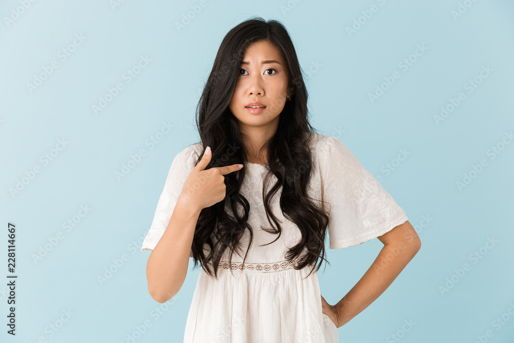 Nervous asian beautiful woman isolated over blue background pointing. Nervous asian beautiful woman isolated over blue background pointing.