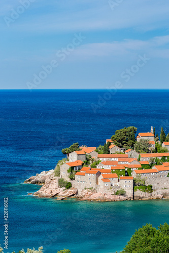 Springtime blue water landscape view of St. Stephan island in Adriatic Sea in Montenegro, famous tourist and holiday destination in Europe with stunning architecture and crystal sea waters