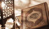 Islamic Book Koran with rosary on grey