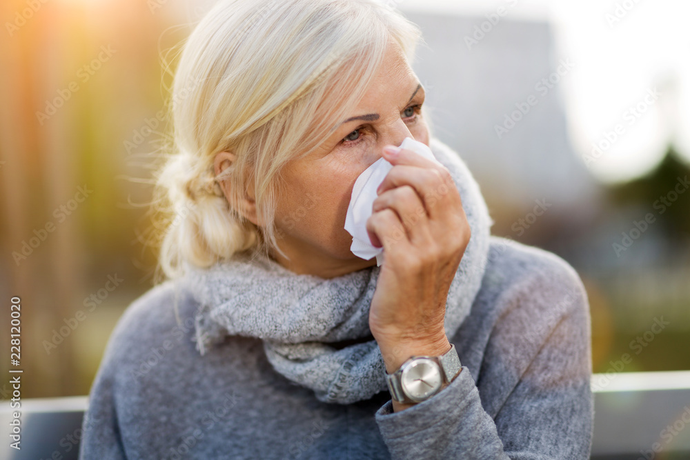 Sick woman blowing her nose
Sick woman blowing her nose