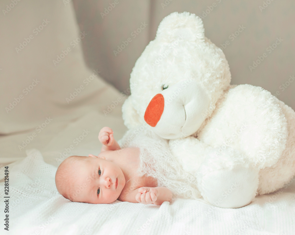 portrait of a newborn baby with a soft toy in the parents ' bed portrait of a newborn baby with a soft toy in the parents ' bed