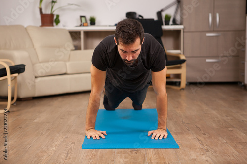 bearded man doing push ups on the floor of his house. Practice makes it better. © DC Studio