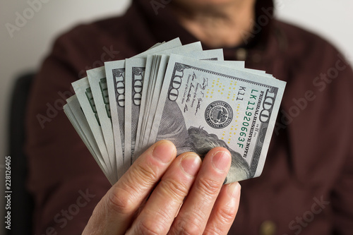 USA currency. Dollars. Front view of old woman's hand handling bills.
