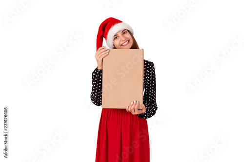 Happy brunette girl in christmas hat hugs the gift box. isolated on white background. holidays concept
