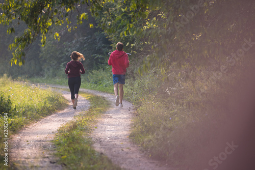 young couple jogging along a country road