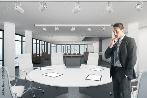 Attractive businessman in bright meeting room