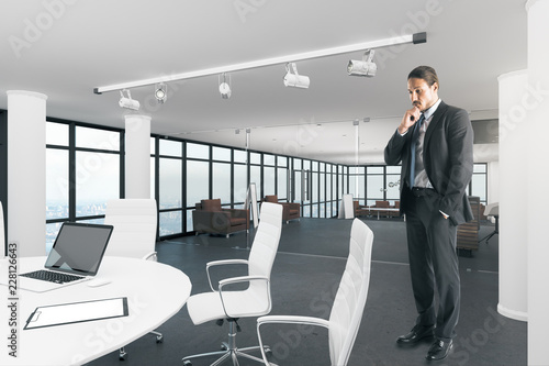 Attractive businessman in contemporary meeting room