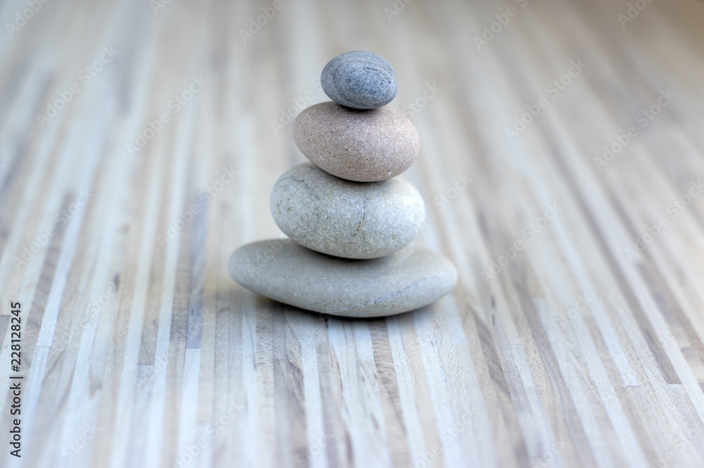 Stone cairn on striped grey white background, four stones tower, simple poise stones, simplicity harmony and balance, rock zen