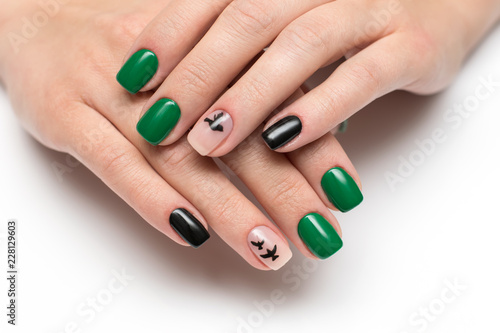 green black manicure with painted black flying birds on square short nails on a white background close-up