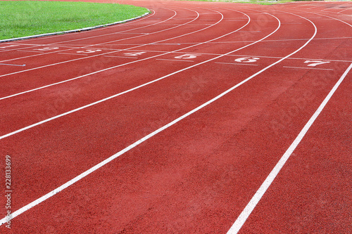 Photo of red running track for competition or exercise  as background. Sports concept. Colorful tone.