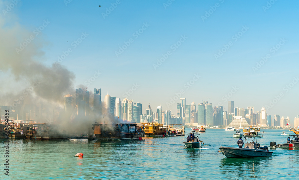 Traditional arabic dhow on fire in Doha, Qatar Traditional arabic dhow on fire in Doha, Qatar